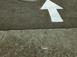 white arrow sign on gray concrete floor