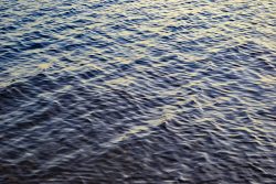 a large body of water with a boat in the distance